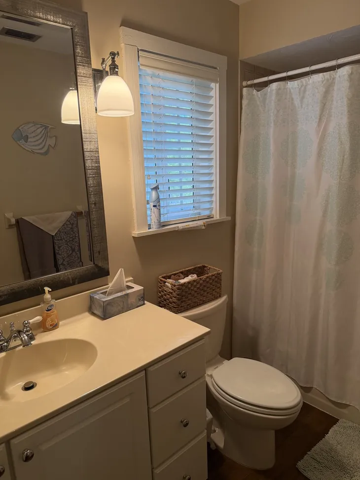 The upstairs bathroom with a tub and shower, serving the two third-floor bedrooms