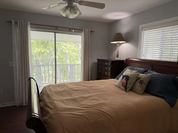 Third-floor bedroom with a queen bed and a balcony door