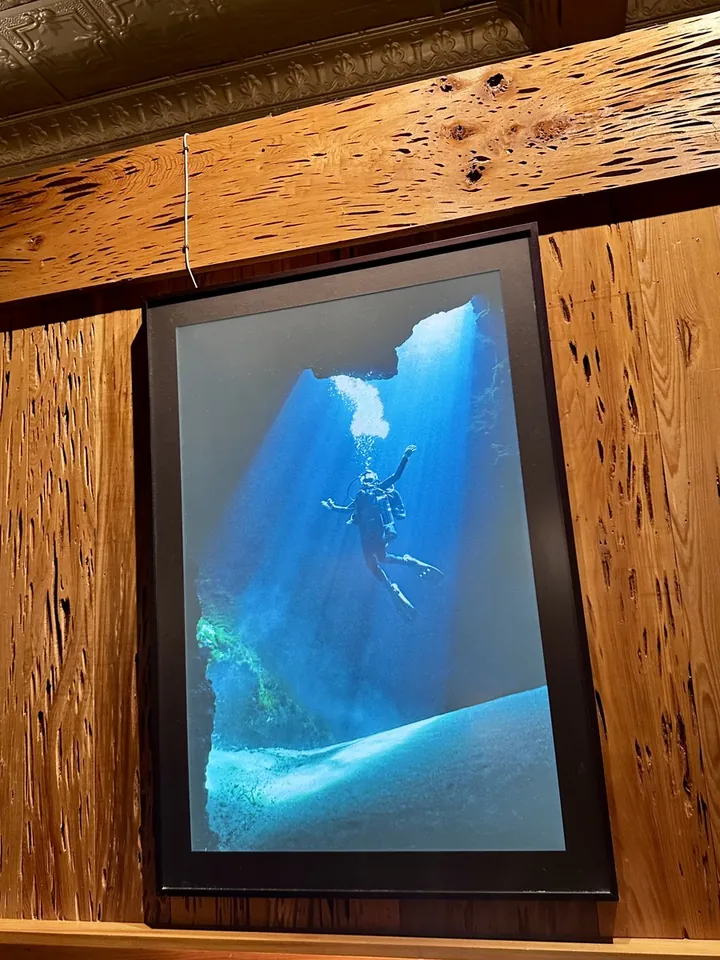 A framed photograph of a diver in a spring, hanging on the pecky cypress wall at The Great Outdoors Restaurant