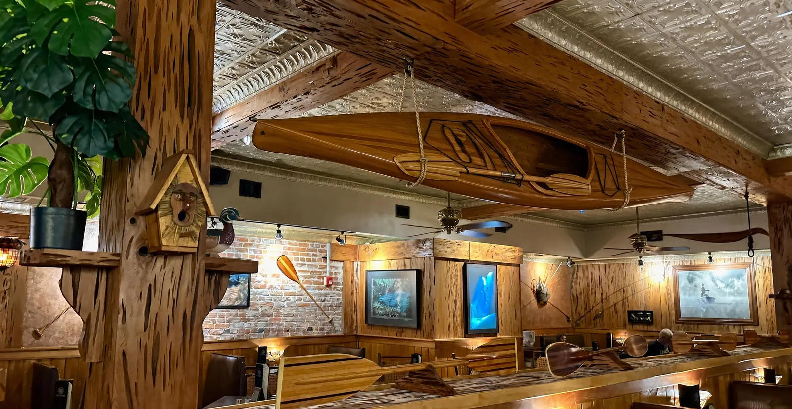 The dining room at The Great Outdoors Restaurant, with a cedar-strip kayak hung from the pressed-tin ceiling above the booths