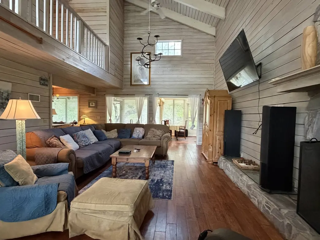 The vaulted great room with its stone fireplace and third-floor walkway